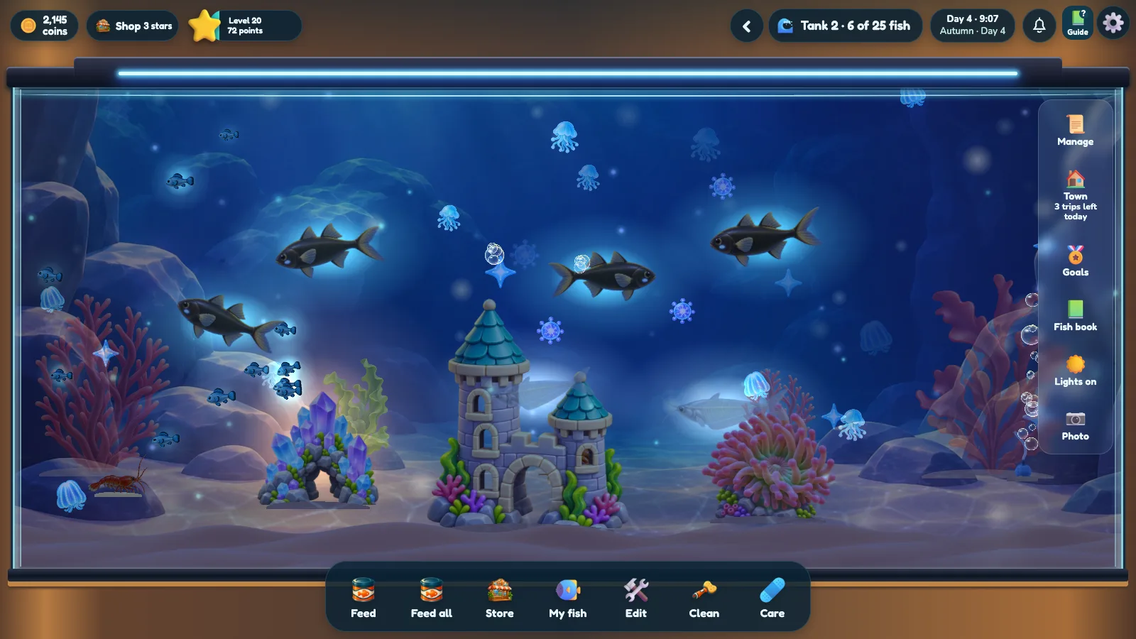 A second Fintopia aquarium with dark fish, coral and a castle decoration